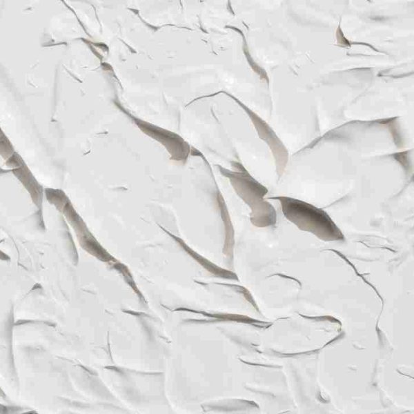 Thick white clay or cream texture with bold spatula ridges and soft shadows, abstract background for luxury skincare branding.
