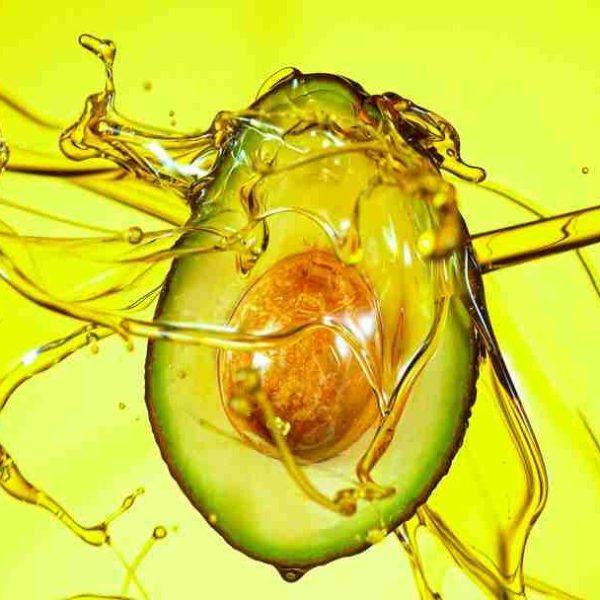 Fresh cut avocado with oil stream. Concept of healthy fruit also useful in cosmetics.