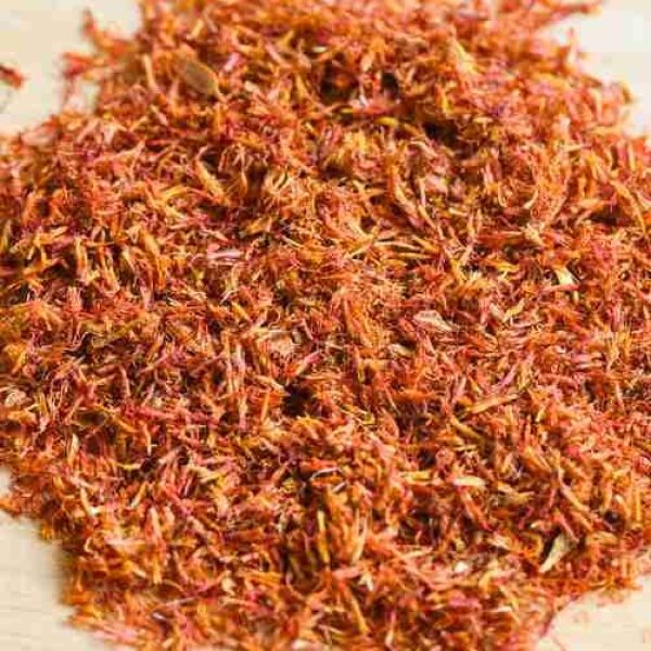 Dried safflower for herbal tea on tray wooden background, dry safflower petals, Saffron substitute